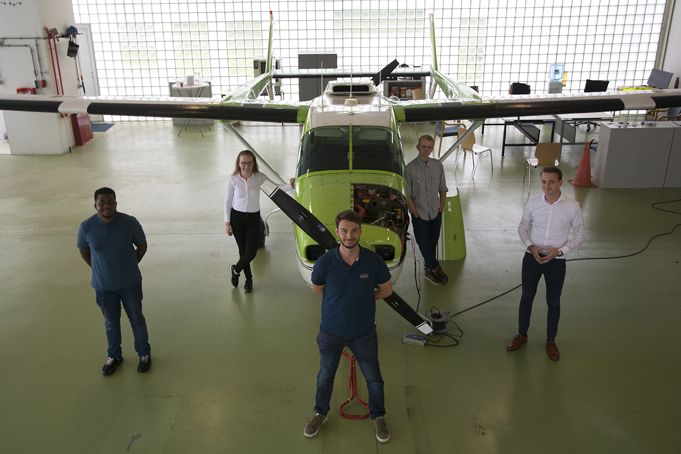 Vijf studenten van de Hogeschool van Amsterdam voor het testvliegtuig van DEAC.